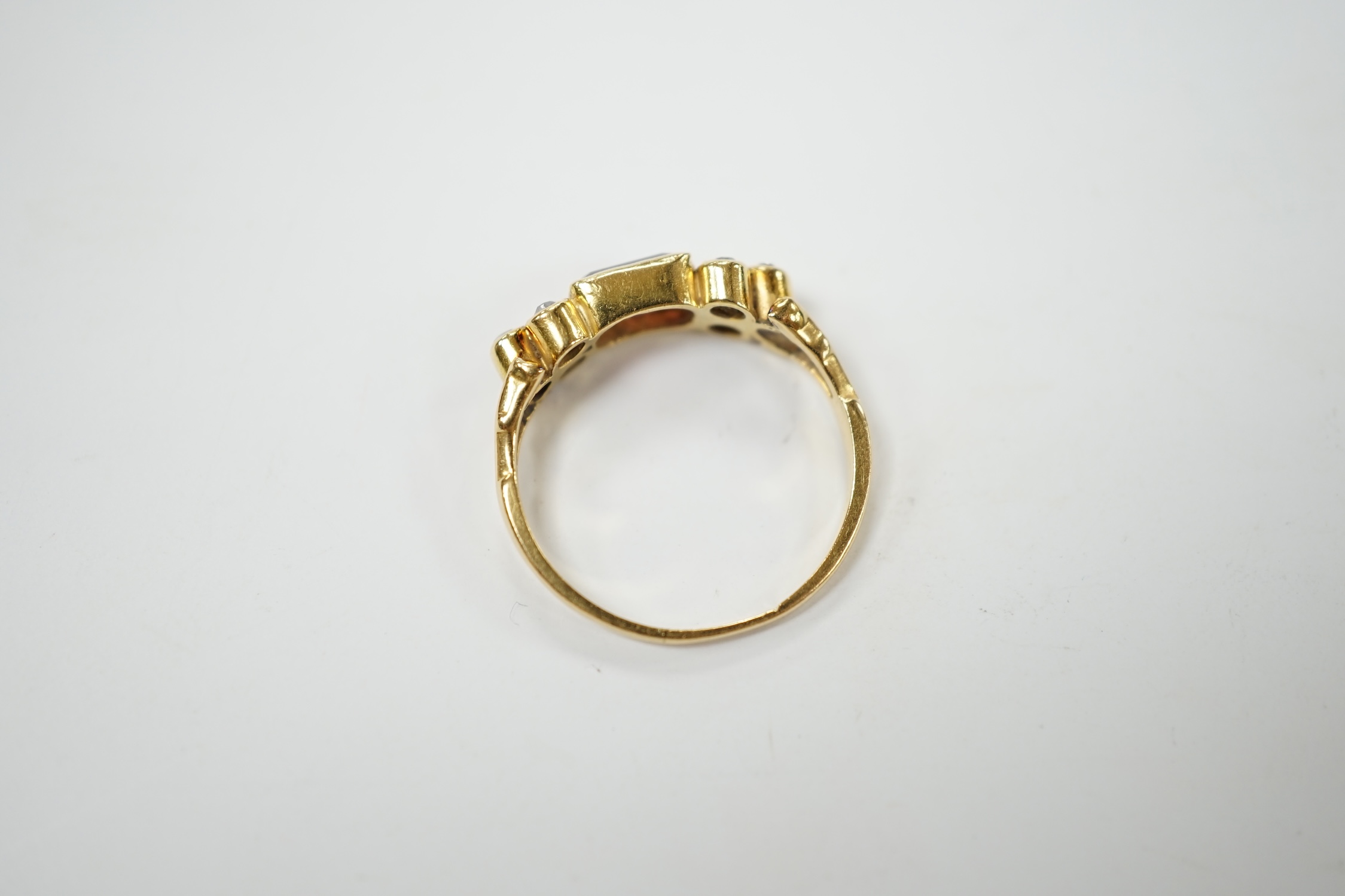 A yellow metal and single stone rectangular cut garnet? set ring, with six stone diamond set shoulders, size L, gross weight 2.5 grams. Condition - poor to fair